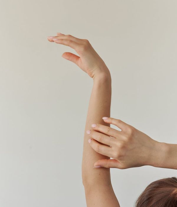 Woman in a flowing yoga pose on a light background.